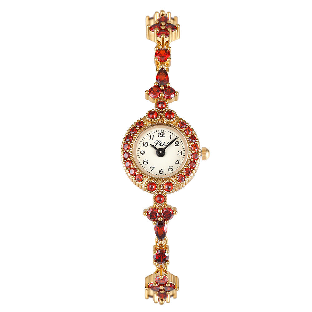 Victorian Style Watch with red gemstones and gold-tone bracelet.