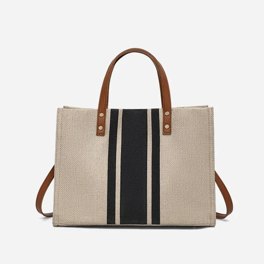 Stylish canvas bag with leather handles and striped detailing.