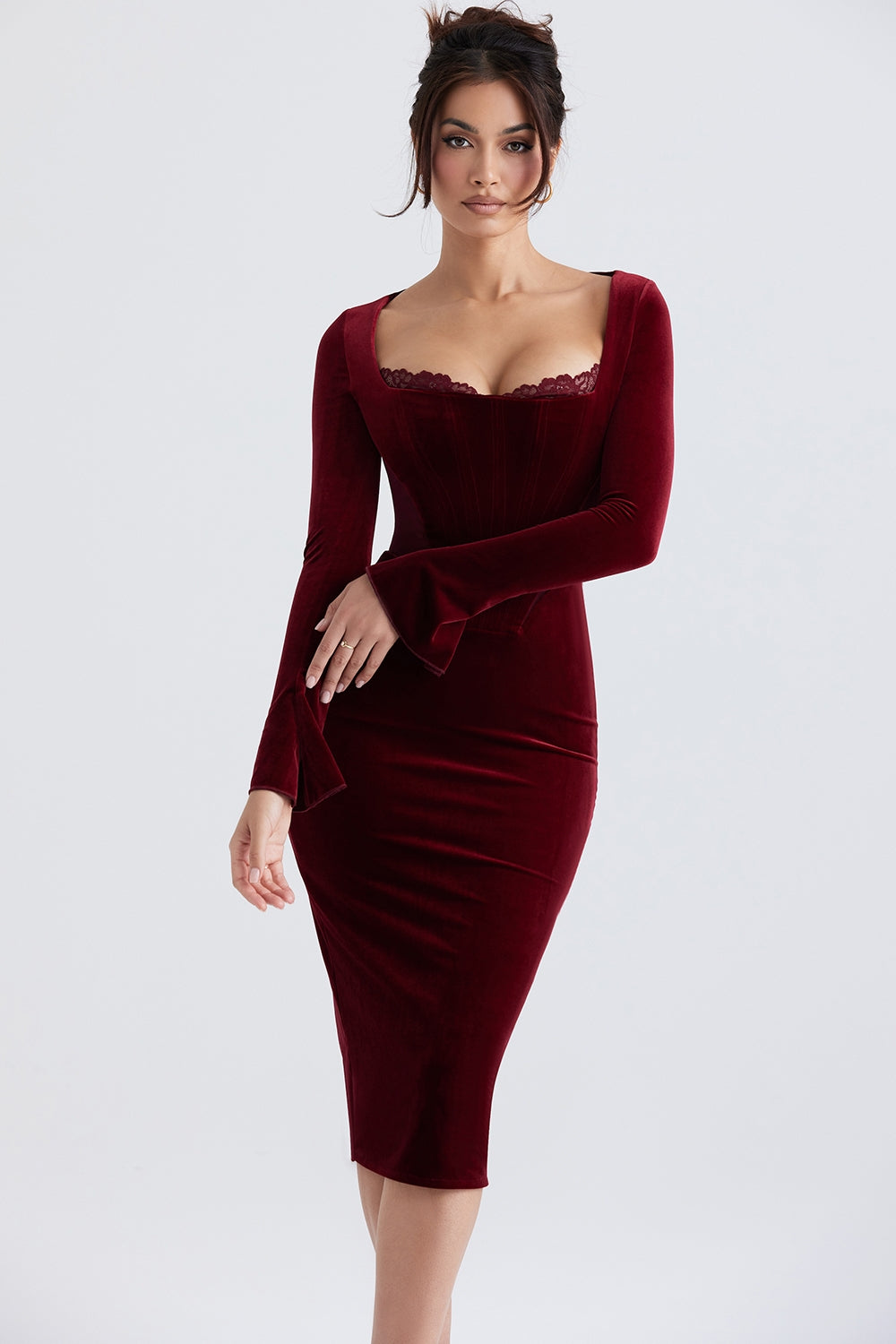 Elegant red velvet corset dress with long sleeves and fitted silhouette.